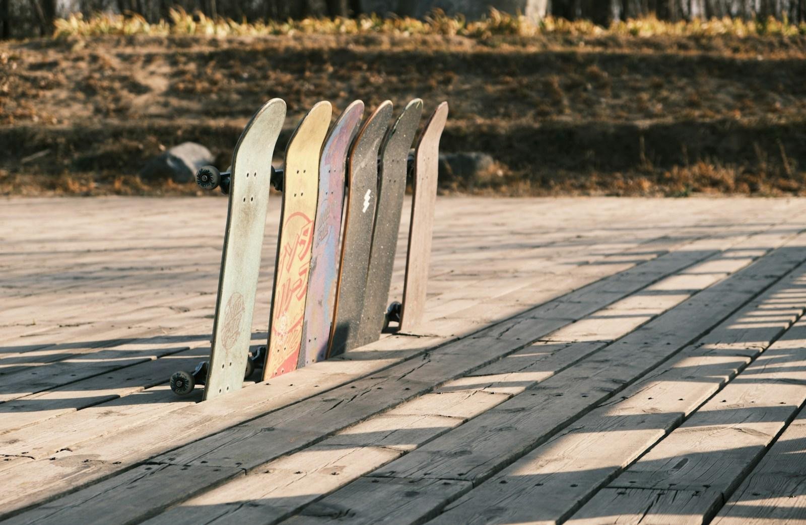 a row of skateboards sitting on top of a wooden floor